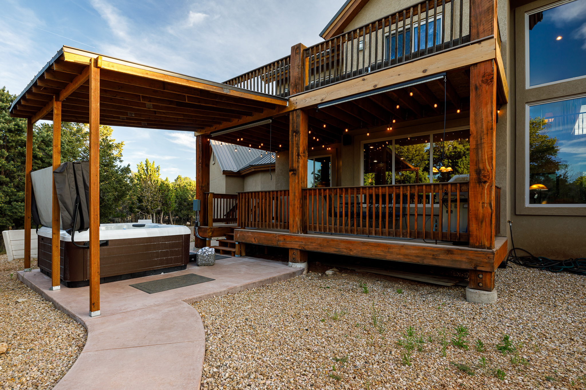 Hot tub in the backyard and back patio with grill and dining area